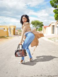 Young woman posing while standing on road