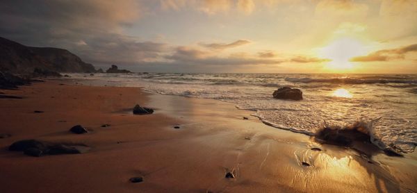 Scenic view of beach against sky during sunset