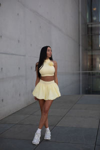 Young woman standing against wall