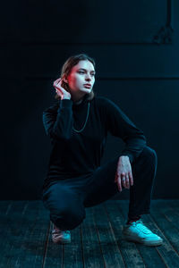 Portrait of young woman sitting on hardwood floor