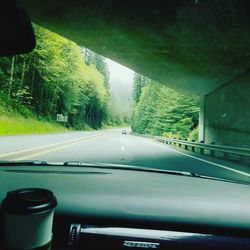 Car on road seen through wet window