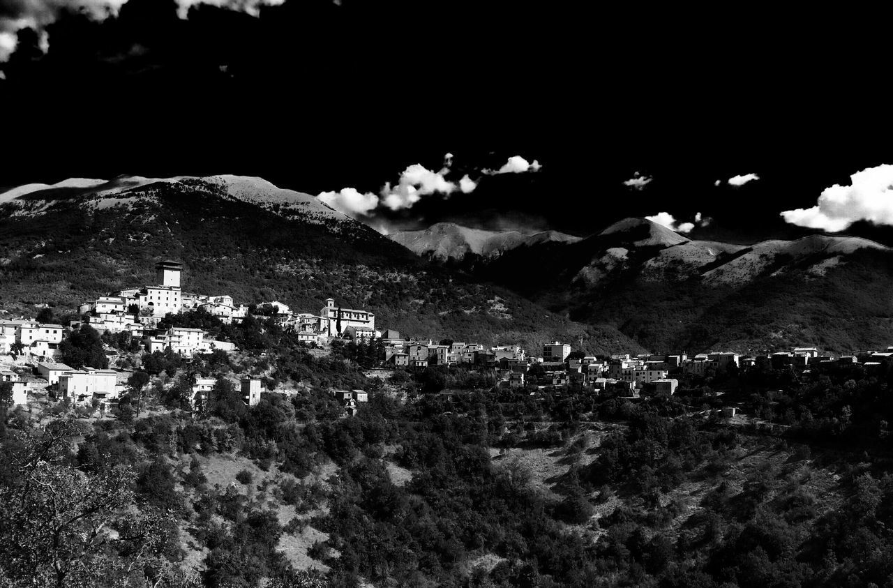 HOUSES IN TOWN AGAINST MOUNTAINS