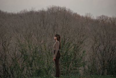 Rear view of woman standing on field