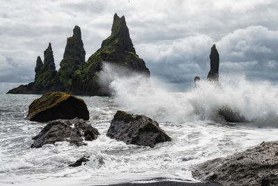 Scenic view of rocks in sea against sky