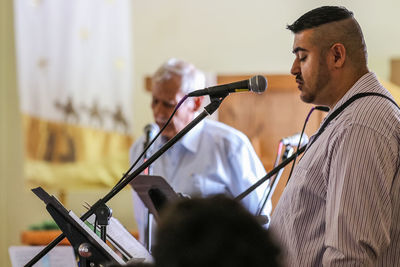 Men singing through microphones