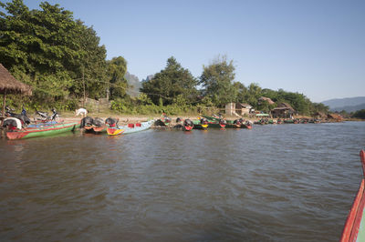 People on boats in sea against sky