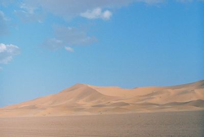 Scenic view of desert against blue sky