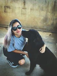 Woman wearing sunglasses sitting with dog