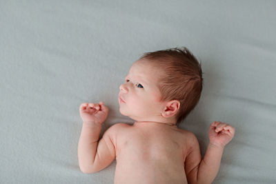 Cute baby girl lying on bed at home