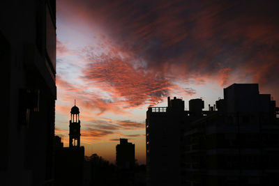 Low angle view of buildings against dramatic sky