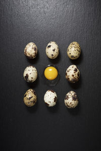 Quail eggs on a black table.