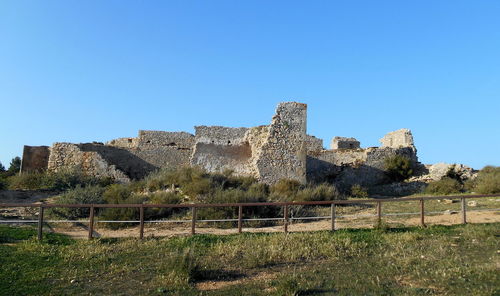 Old ruin building against clear blue sky