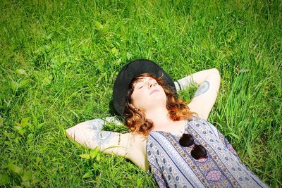 High angle view of young woman sleeping on grassy field