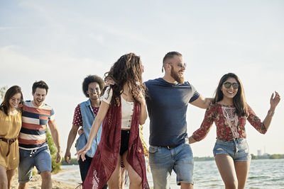 Happy friends walking at beach 