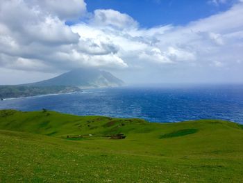 Scenic view of green landscape against sky