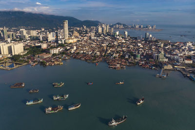 High angle view of boats in sea against buildings in city