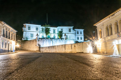 Street amidst buildings in city at night