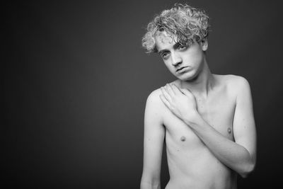 Portrait of shirtless man against black background