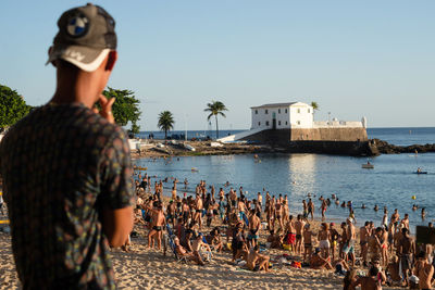 People at beach against clear sky