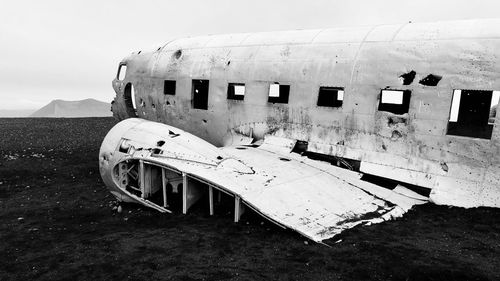 Abandoned airplane on runway against sky