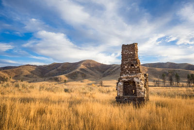 Built structure on countryside landscape against mountain range