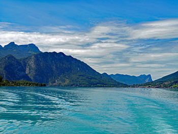 Scenic view of sea and mountains against sky