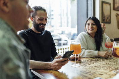 Smiling young woman sitting at table