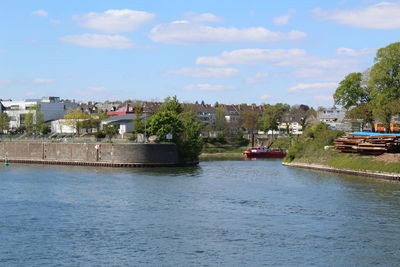 Scenic view of river by town against sky