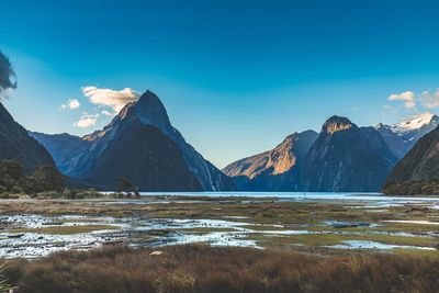 Scenic view of lake by mountains against sky