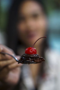 Close-up of woman holding strawberry