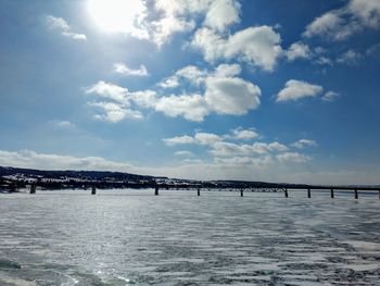 Bridge over river against sky during winter