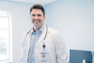 Portrait of happy doctor standing in hospital