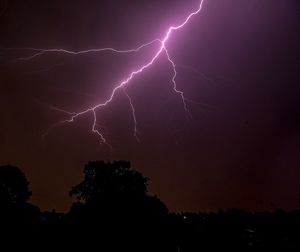 Low angle view of lightning against sky at night