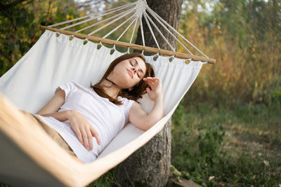 Young woman lying on hammock