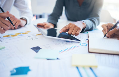 Midsection of business colleagues working on table