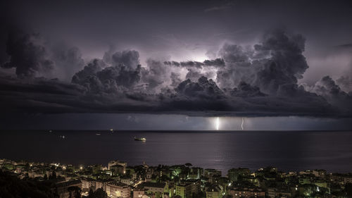 Scenic view of sea and city against sky at night