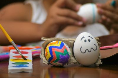 Close-up of colorful painted eggs on table against kid