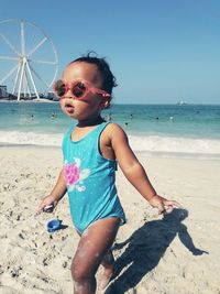 Boy on walking on sand at beach against sky