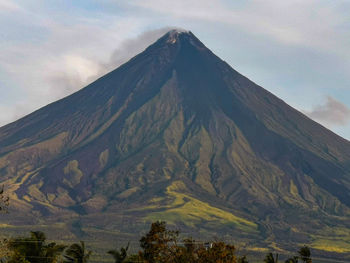 Scenic view of mountain range against cloudy sky
