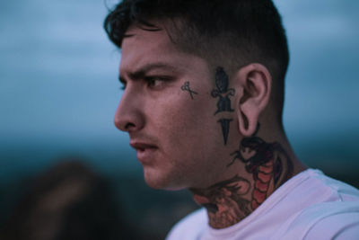 Profile view of man with tattoo looking away