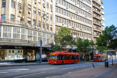 Vehicles on road by buildings in city