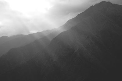 Scenic view of mountains against cloudy sky