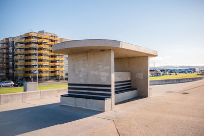 Concrete shelter on promenade against clear blue sky 