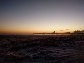 Scenic view of beach against clear sky during sunset