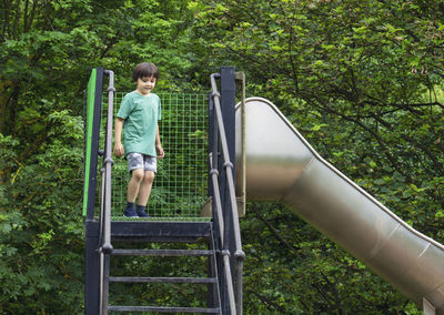 Rear view of boy on slide at playground