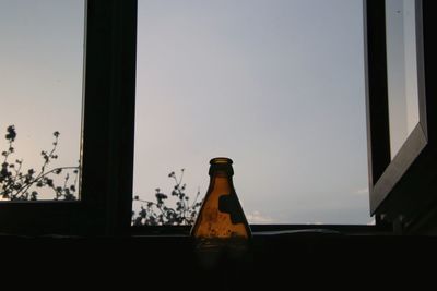 Close-up of glass bottle on table by window