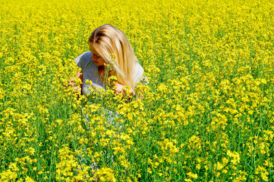 Woman with yellow flowers in field