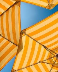 Low angle view of yellow parasol against clear sky