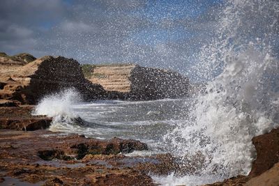 Sea waves splashing against sky