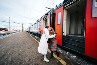 Girls say goodbye hugging on the station platform